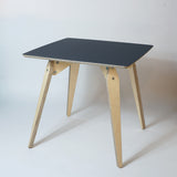 square plywood dininhg table with black top on an angle