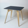 square plywood dininhg table with black top on an angle